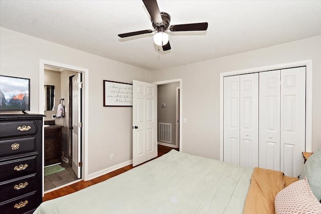 bedroom featuring a textured ceiling, a closet, ceiling fan, and dark wood-type flooring