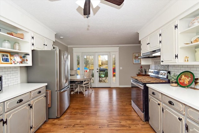 kitchen with tasteful backsplash, white cabinetry, stainless steel appliances, and dark hardwood / wood-style floors