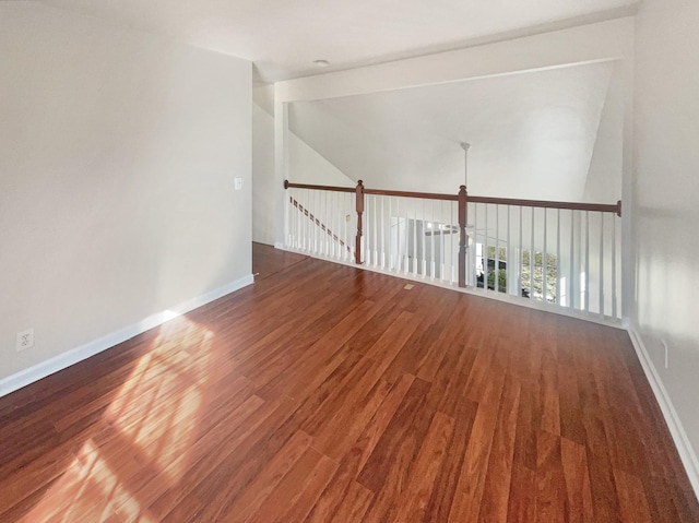 spare room featuring hardwood / wood-style floors and lofted ceiling