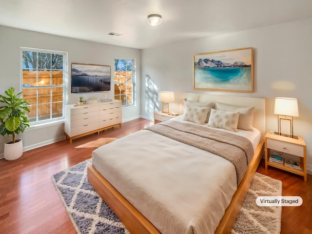 bedroom featuring multiple windows and hardwood / wood-style flooring