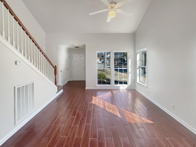 interior space with ceiling fan, a high ceiling, and dark hardwood / wood-style floors