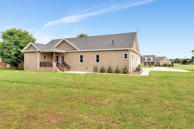 back of house featuring central air condition unit and a lawn