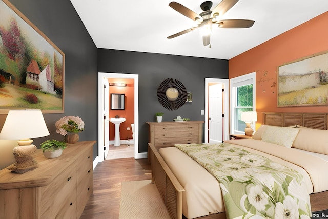 bedroom with light wood-type flooring, ensuite bath, ceiling fan, and sink