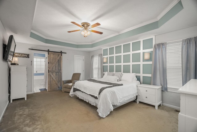 bedroom with carpet, ensuite bathroom, a raised ceiling, ceiling fan, and a barn door