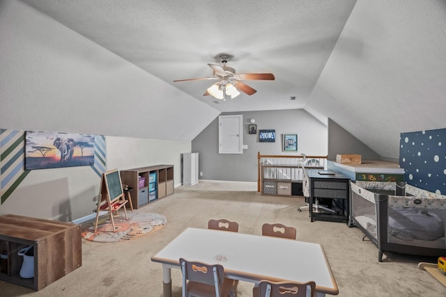 playroom featuring a textured ceiling, ceiling fan, light carpet, and vaulted ceiling