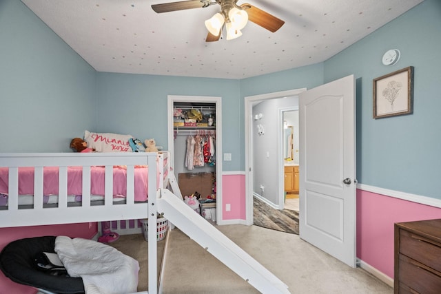 bedroom featuring ceiling fan, light carpet, and a closet