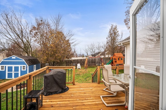 wooden deck with a playground and a yard