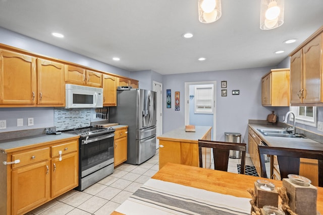 kitchen with decorative backsplash, sink, light tile patterned floors, and appliances with stainless steel finishes