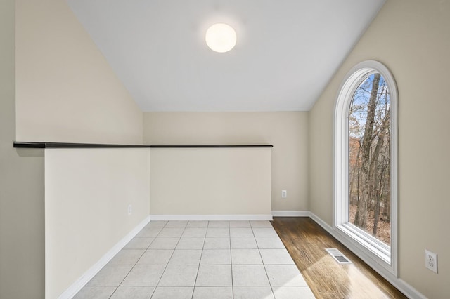 unfurnished room featuring light wood-type flooring and vaulted ceiling