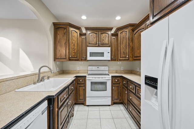 kitchen with sink, light tile patterned floors, and white appliances