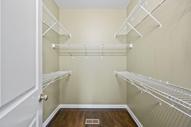 walk in closet with dark wood-type flooring