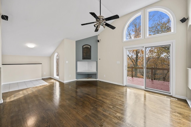 unfurnished living room with ceiling fan, high vaulted ceiling, and wood-type flooring