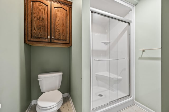 bathroom with toilet, tile patterned floors, and a shower with door