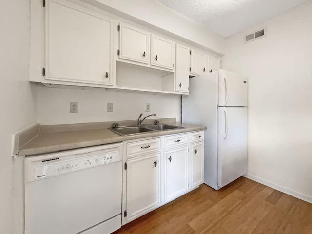 kitchen with a textured ceiling, white appliances, sink, light hardwood / wood-style flooring, and white cabinets