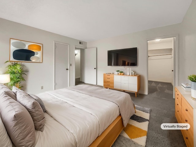 bedroom with dark carpet, a spacious closet, and a closet