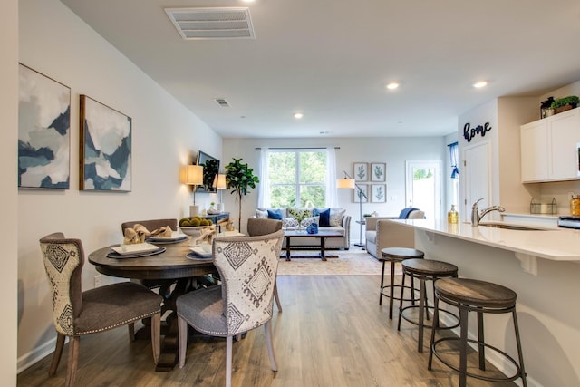 dining area featuring sink and light hardwood / wood-style flooring