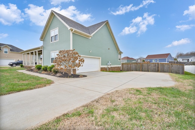 view of side of home featuring covered porch, a yard, and a garage