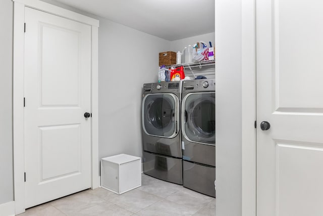 laundry room with light tile patterned floors and washer and clothes dryer