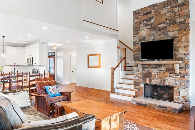 living room featuring a fireplace, light hardwood / wood-style floors, and ornamental molding