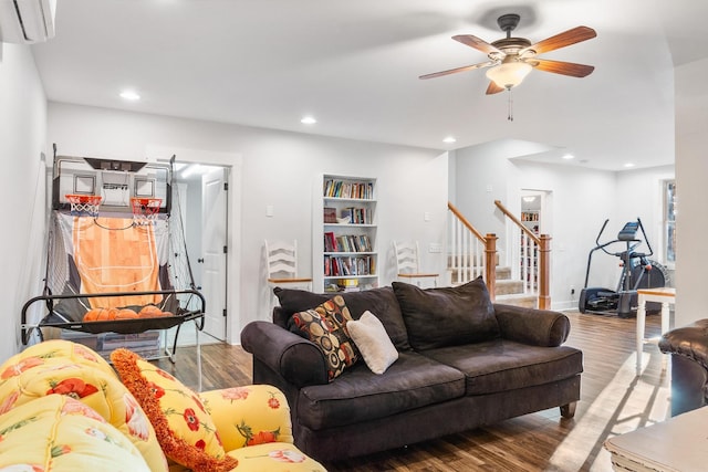 living room with ceiling fan, a wall mounted air conditioner, and hardwood / wood-style flooring