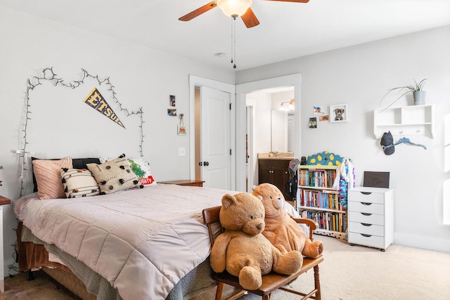 carpeted bedroom with ensuite bath and ceiling fan