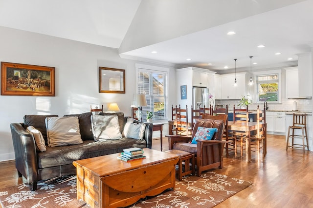 living room featuring crown molding, vaulted ceiling, and hardwood / wood-style flooring