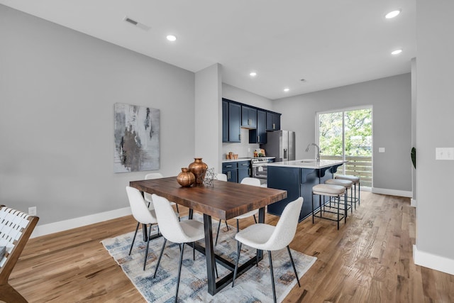 dining area with light hardwood / wood-style flooring and sink