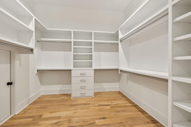 walk in closet with light hardwood / wood-style floors