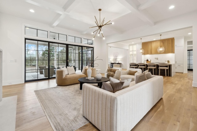 living room featuring coffered ceiling, an inviting chandelier, light wood-type flooring, and beam ceiling