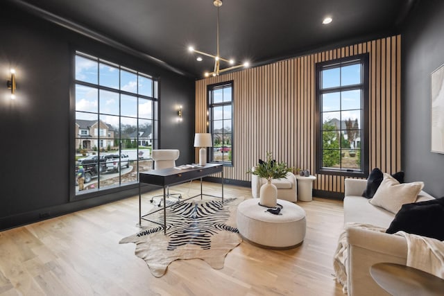 office space with light hardwood / wood-style floors, a healthy amount of sunlight, and a chandelier