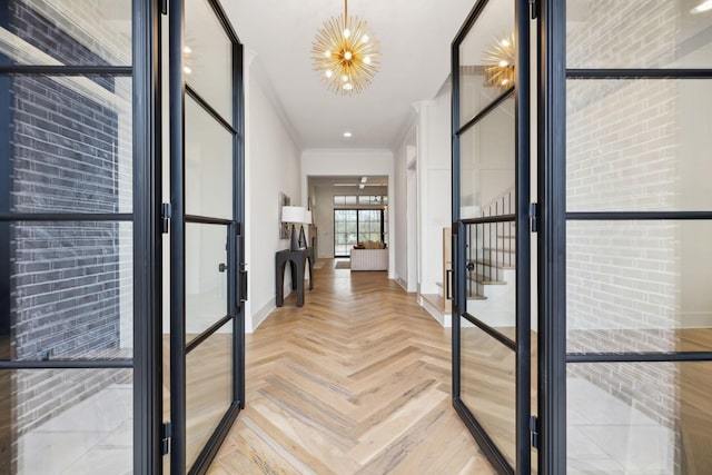 hall with a notable chandelier, ornamental molding, and parquet flooring