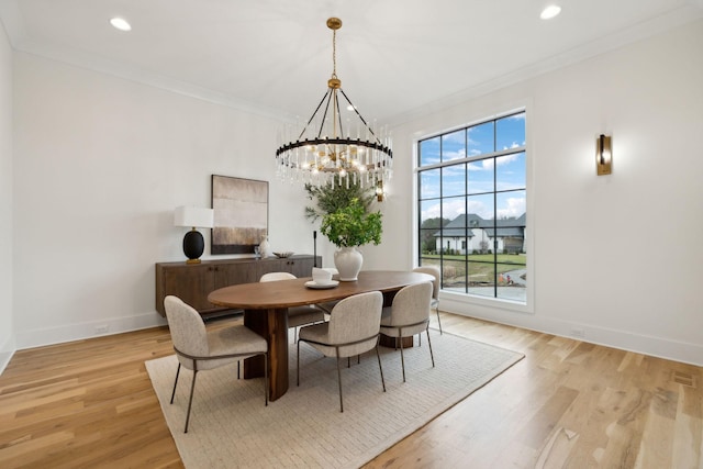 dining space with light wood-type flooring, crown molding, and a chandelier