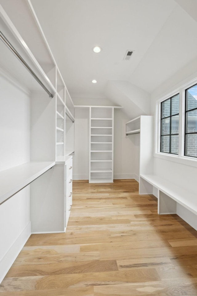 spacious closet with lofted ceiling and light hardwood / wood-style floors