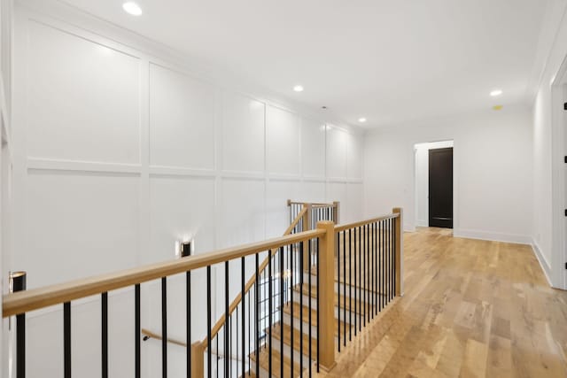 hallway featuring light wood-type flooring and ornamental molding