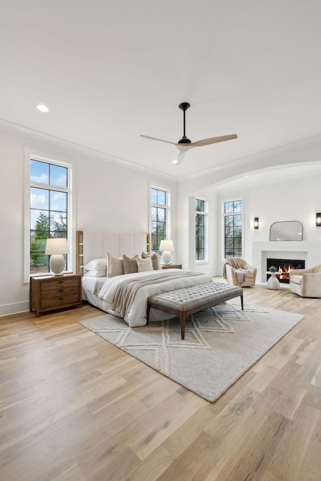 bedroom with ceiling fan, crown molding, and light hardwood / wood-style flooring