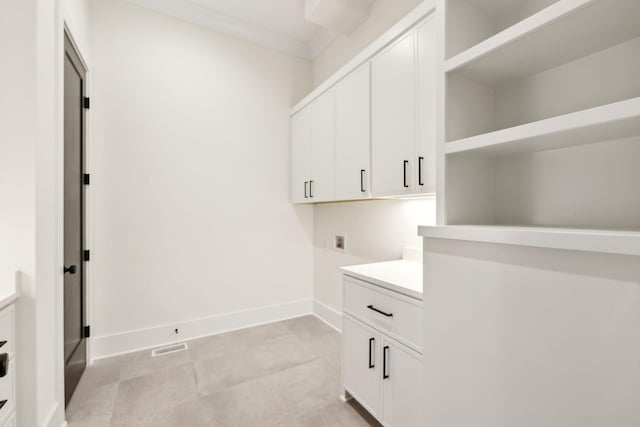 laundry room featuring crown molding, hookup for a washing machine, and cabinets