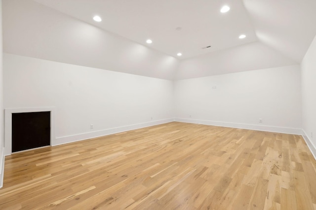 interior space featuring light wood-type flooring and vaulted ceiling