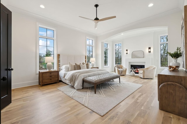 bedroom with ceiling fan, ornamental molding, and light hardwood / wood-style flooring