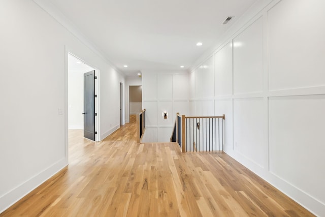 hall featuring ornamental molding and light hardwood / wood-style floors