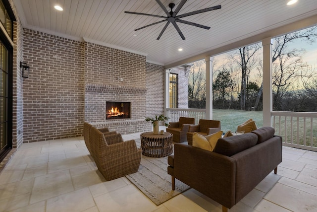 sunroom featuring ceiling fan and an outdoor brick fireplace