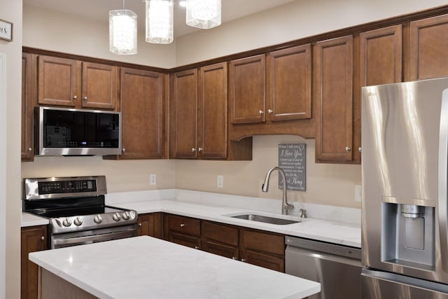 kitchen with decorative light fixtures, sink, and appliances with stainless steel finishes