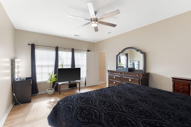 bedroom with ceiling fan, light hardwood / wood-style floors, and multiple windows