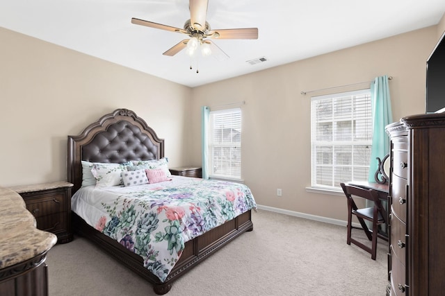 bedroom with light colored carpet, multiple windows, and ceiling fan