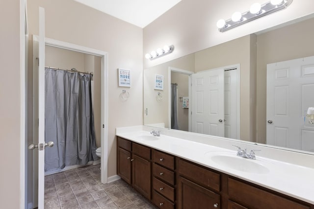 bathroom with walk in shower, vanity, and toilet