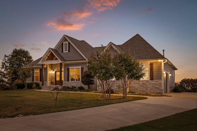 craftsman house with a garage and a yard