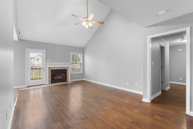 unfurnished living room with high vaulted ceiling, ceiling fan, dark wood-type flooring, and a tile fireplace