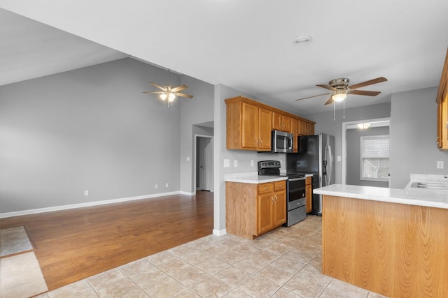 kitchen with stainless steel appliances, ceiling fan, sink, light hardwood / wood-style floors, and lofted ceiling