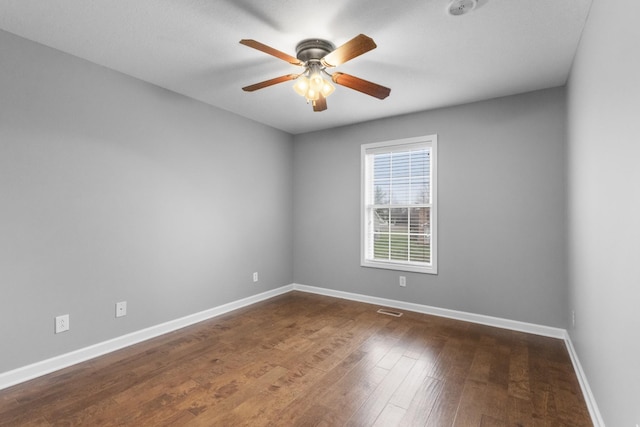 spare room featuring ceiling fan and dark wood-type flooring