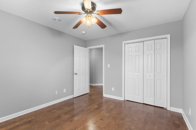 unfurnished bedroom featuring a closet, ceiling fan, and dark wood-type flooring