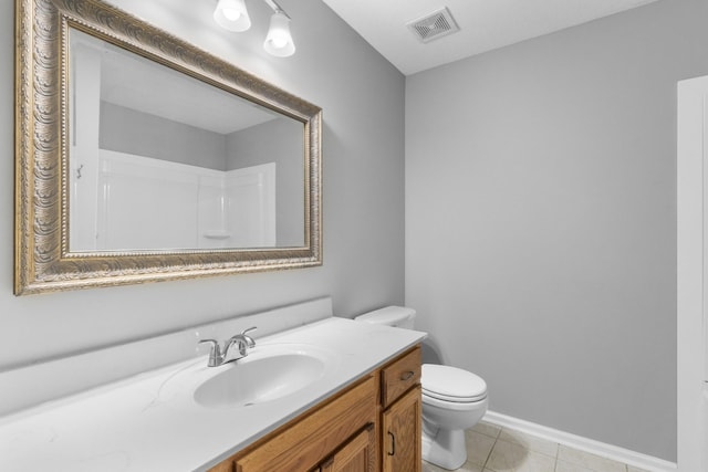 bathroom with tile patterned flooring, vanity, toilet, and walk in shower